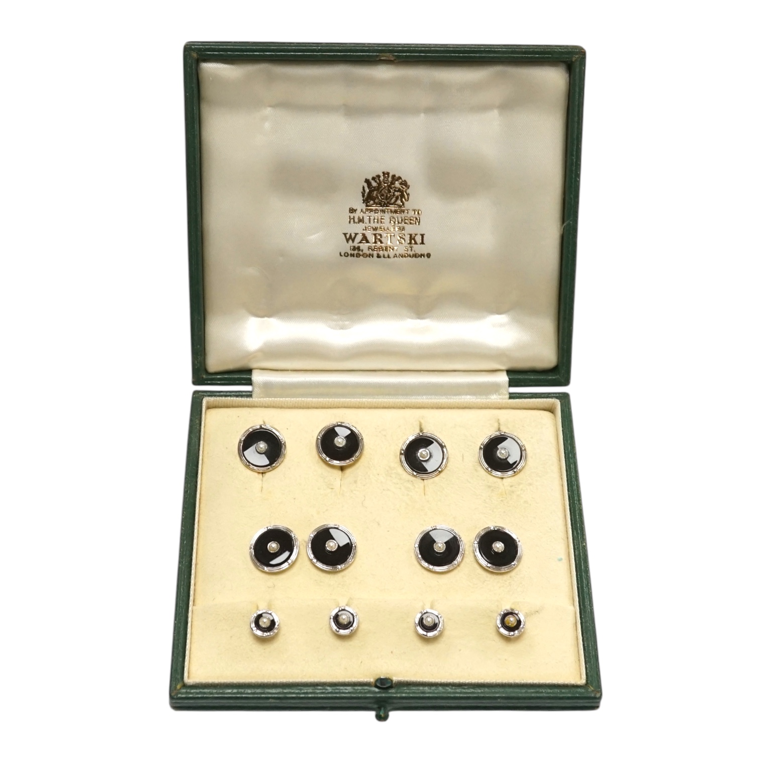 A 1960's 9ct white metal, black enamel and seed pearl set nine piece dress stud set by Cropp & Farr, housed in a Wartski fitted leather case. Condition - good